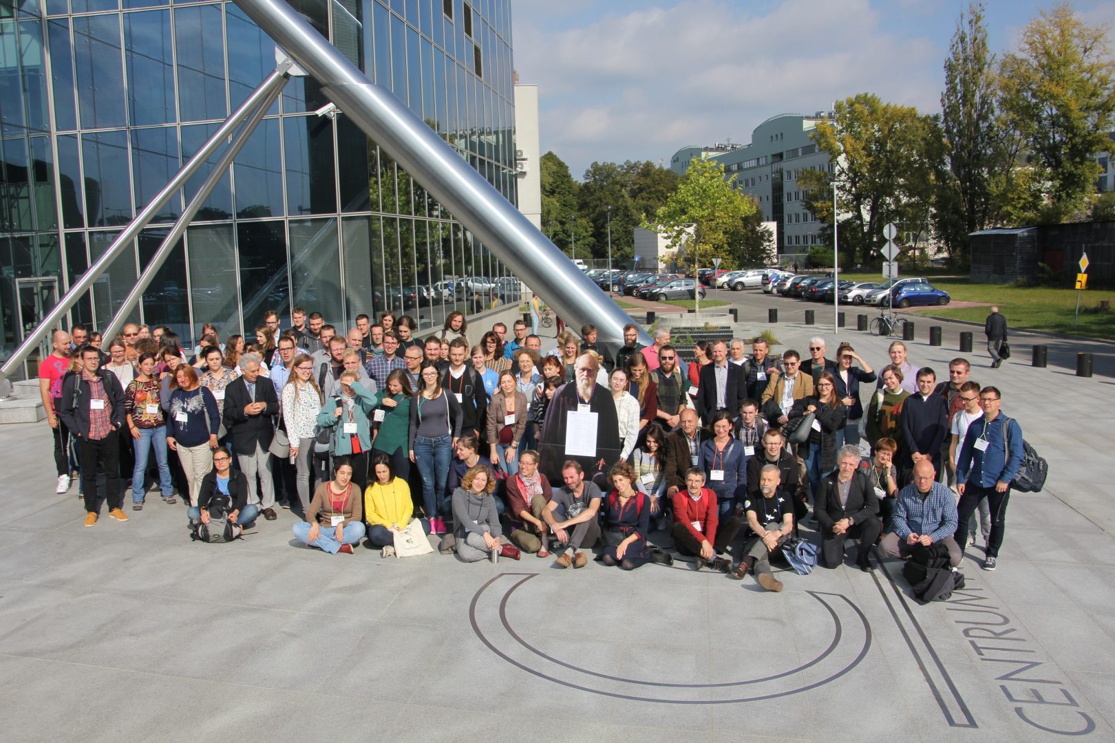 Participants of the 6th PEC - Warsaw 2018 gathered in the square in front of the University building. Among the participants stands the figure of Charles Darwin.